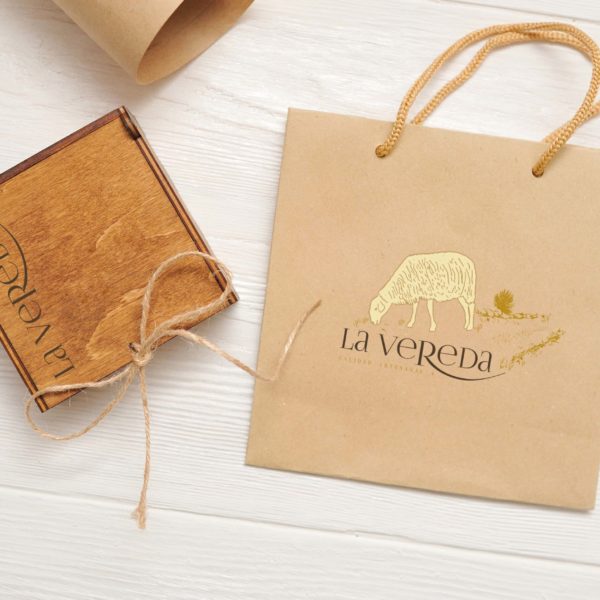 Mock up craft paper shopping bag with kraft paper and wooden box on vintage wooden white table background. Top view.